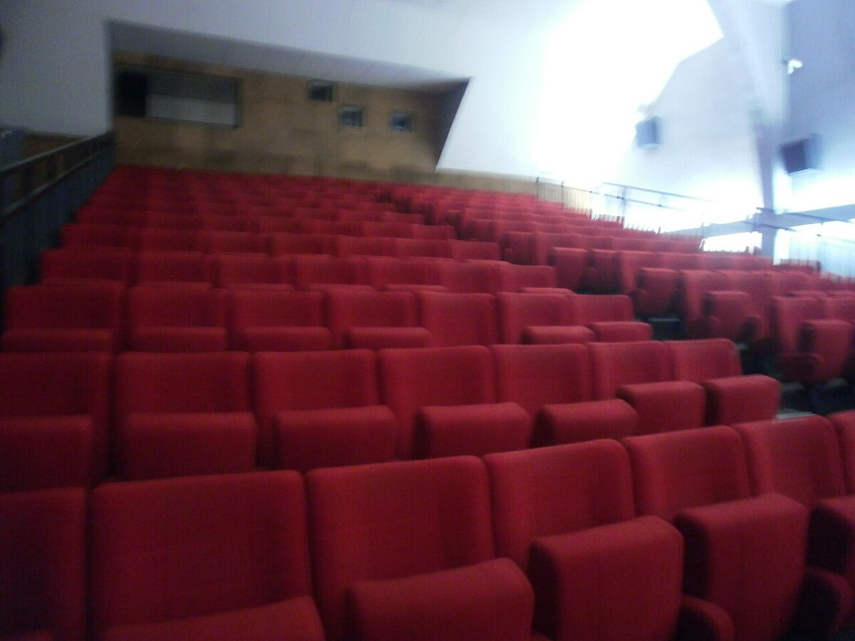 Rangées de fauteuils rouges dans une salle de cinéma