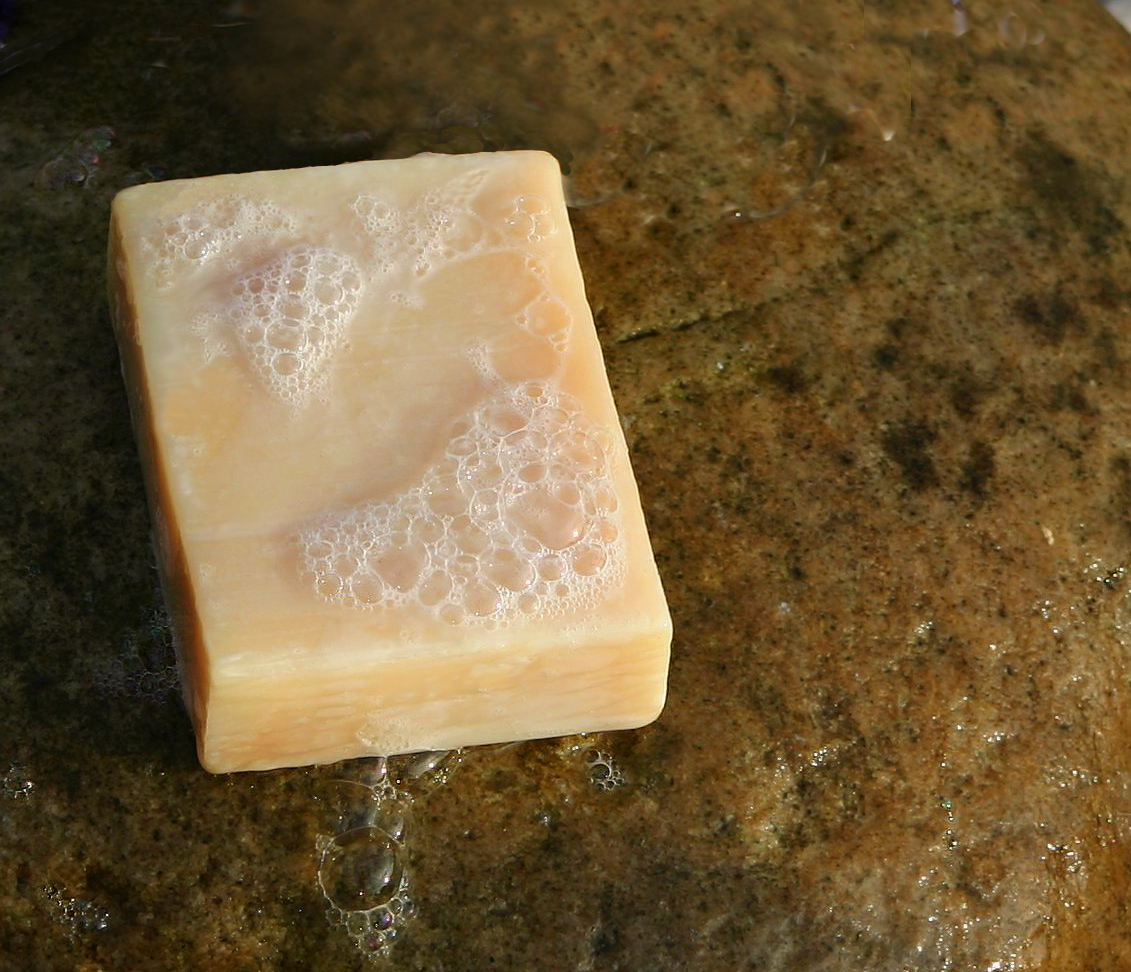 Un savon artisanal posé sur une pierre mouillée